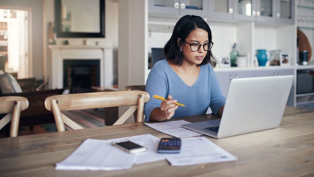 Shot of a young woman using a laptop (technology) while working remotely, working from home